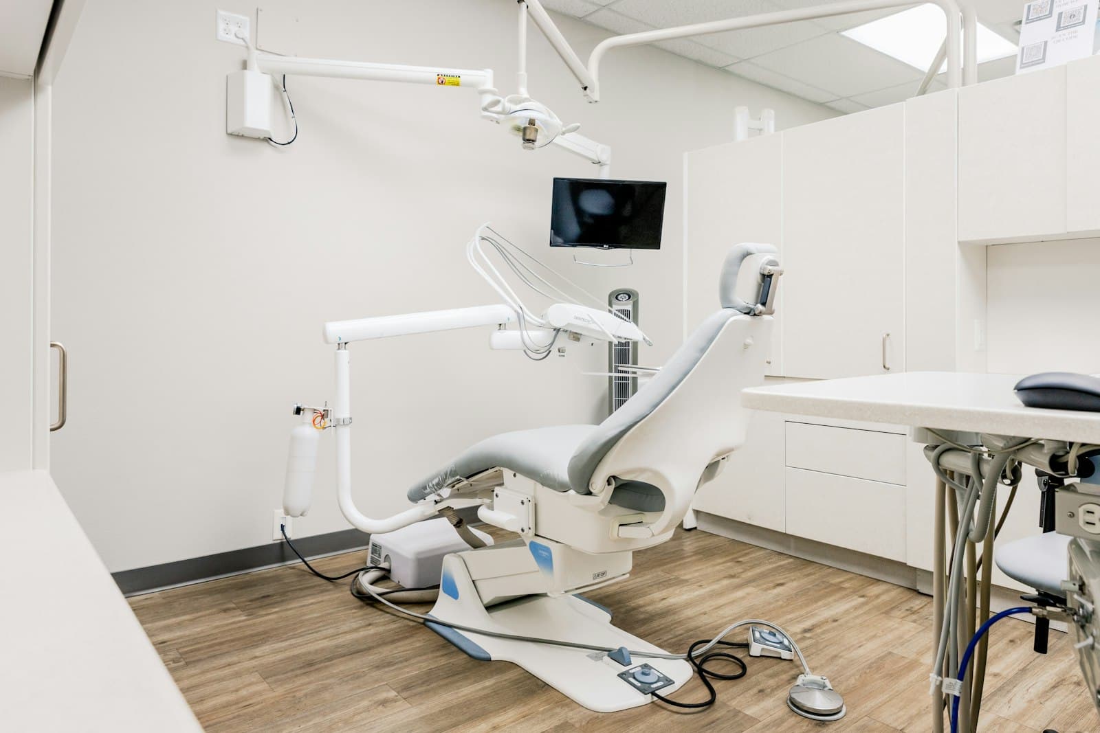 A clean, bright dental treatment room with a modern dental chair and natural light